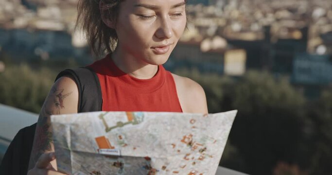 Profile of brunette exploring romantic Florence during summer vacation. Portrait of excited female tourist looking on city map standing at the viewpoint in the background of Santa Maria del Fiore .