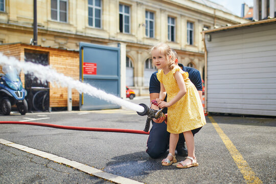 Adorable preschooler girl acting like a fireman