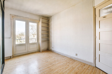an empty room with wood flooring and white paint on the walls, there is a door in the corner