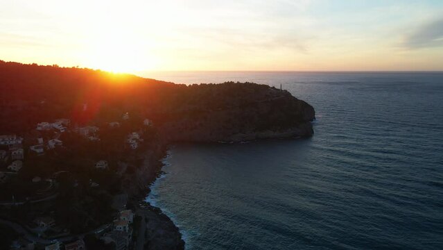 Panning aerial shot of dramatic Spanish sunset Soller Mallorca Port Harbour Lighthouse Summer