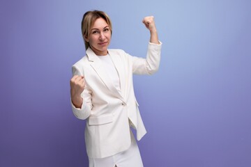 blond young business lady in an elegant jacket posing confidently on a studio background