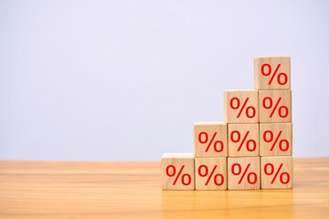 Concept of interest rates on finance and loans. wooden cube block above with percentage symbol.