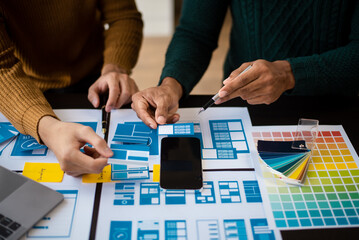  UX developer and ui designer brainstorming about mobile app interface wireframe design with...