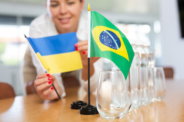 Little flag of Brazil on table with bottles of water and flag of Ukraine put next to it by positive...