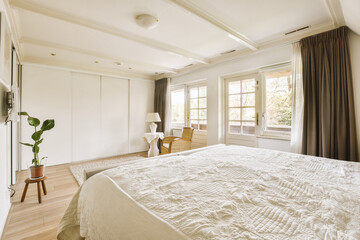 a bedroom with a bed, chair and desk in the corner of the room on the left is a window