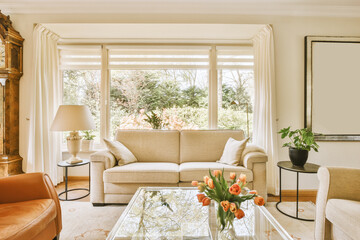 a living room with two couches and a glass coffee table in front of the sofa is surrounded by white curtains