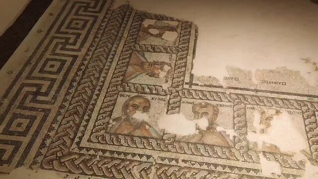 Antalya, Turkey, June 12, 2023. Ancient Roman brown floor mosaic depicting people and decorative patterns