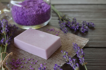 Lavender Spa products and lavender flowers on a table. Handmade soap, essential oil and lavender bath salt - beauty treatment. Healthy skin care. SPA concept. Side view, copy space for text. 