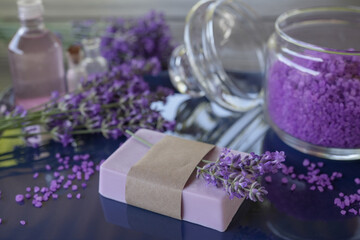 Obraz na płótnie Canvas Lavender Spa products and lavender flowers on a table. Handmade soap, essential oil and lavender bath salt - beauty treatment. Healthy skin care. SPA concept. Side view.