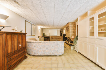 a living room with white walls and wood furniture in the center of the room is an open kitchen, dining area