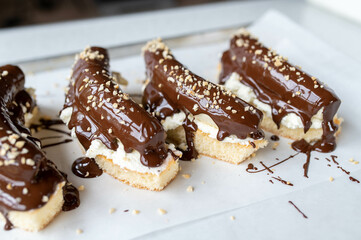 Chocolate banana cake with whipped cream and warm and melted dark chocolate on biscuit base