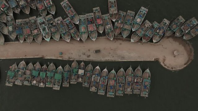 Aerial Birds Eye View Of Fishing Boats Moored Along Jetty At Ibrahim Hyderi In Karachi. Pedestal up