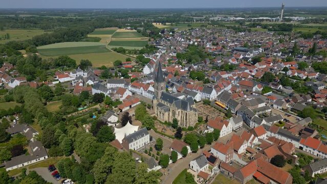 Wide angle drone shot of the municipality of maagouw, thorn in the province of limburg with a view of the Limburg Abbes Church, Wijngaard, historic buildings and the beautiful flat landscape
