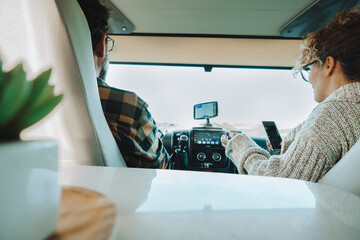 Inside back view of vehicle cabin like motorhome and couple traveling and using gps navigation...