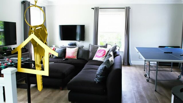 Animation of hanging golden house keys against interior of a modern living room