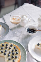 Delicious morning breakfast. Glass with coffee, pie, berries on table.