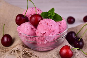 Cherry ice cream in a glass bowl and fresh cherries.Close-up.
