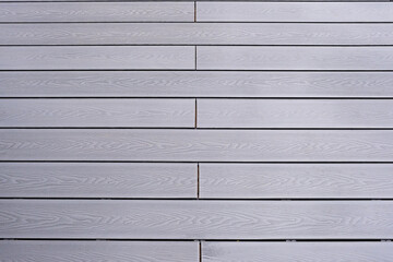 Ash grey composite decking on a rainy wet day showing the full grain of the decking boards A good...