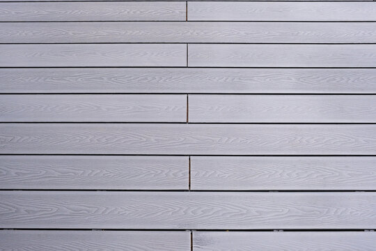 Ash grey composite decking on a rainy wet day showing the full grain of the decking boards A good background image