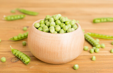 Composition with fresh green peas on wooden table