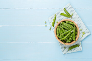 Composition with fresh green peas on wooden background, top view