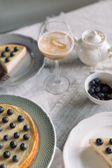 Glass with coffee, blueberry pie on table.