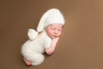 Little charming newborn baby boy sleeps on his stomach. Neutral background. Studio shot of a newborn. Beginning of life.