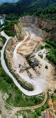 Aerial vertical shot of an industrial limestone quarry on a hill, providing insight into the vast...