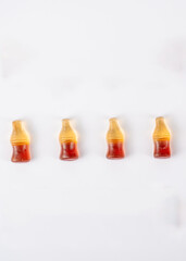 Cola flavored gummy jellies in the shape of cola bottles,isolated over white background.