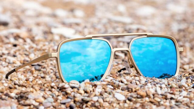 Mirrored sunglasses on a beach