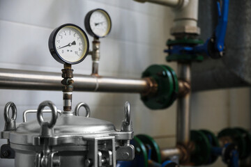 Pressure gauges and pipes indoors, space for text. Production machinery at modern granary