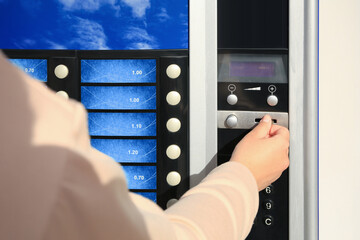 Using coffee vending machine. Woman inserting coin to pay for drink, closeup - obrazy, fototapety, plakaty