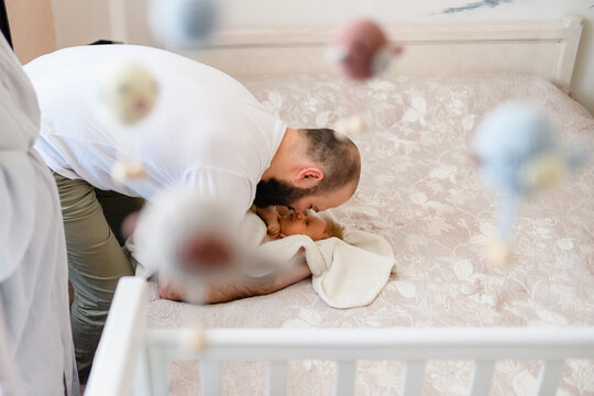 Happy father with newborn in child bedroom