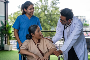 Fototapeta premium A female nurse takes a patient in a wheelchair with a doctor walking in to say hello. Psychology concept, health insurance.