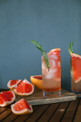 Summer alcohol drinks on table. Cocktail made with tequila, syrup, grapefruit soda and sparkling water.