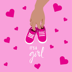 pink slippers in hand on a background with hearts in honor of a girl's birth