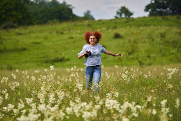 Woman photographer running on a meadow