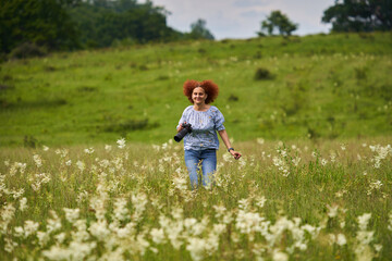 Fototapeta premium Woman photographer running on a meadow