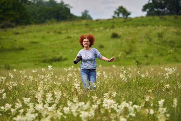 Woman photographer running on a meadow