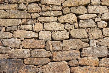 detail of a granitic stone masonry wall, textured background