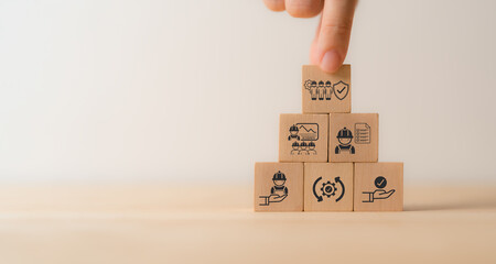 Work safety concept. Wooden cube blocks with icon of safety at workplace surrounded by safety first, protections, health, regulations and compliance. Working standard process. Zero accidents.