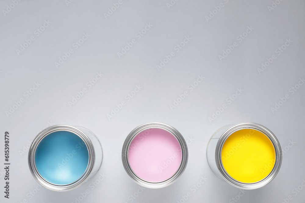 Poster Cans with colorful paints on light background, flat lay. Space for text