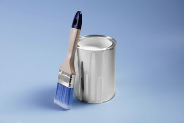 Can of white paint and brush on light blue background