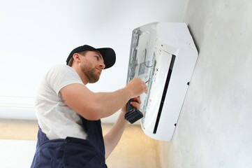 Service man is cleaning, repair and maintenance of air conditioner. - obrazy, fototapety, plakaty