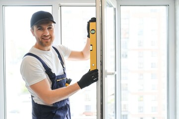 Construction worker repairing window in house.