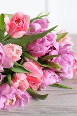 Fototapeta na wymiar Beautiful bouquet of colorful tulip flowers on wooden table, closeup
