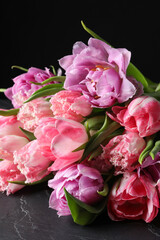 Beautiful bouquet of colorful tulip flowers on black table