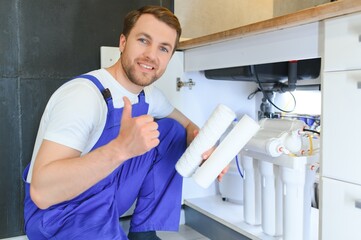 Plumber installs or change water filter. Replacement aqua filter. Repairman installing water filter...