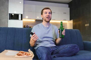 Man eating pizza having a takeaway at home relaxing resting