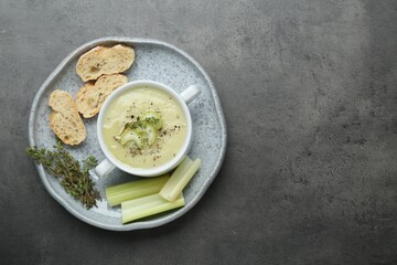 Delicious celery soup on gray table, top view. Space for text